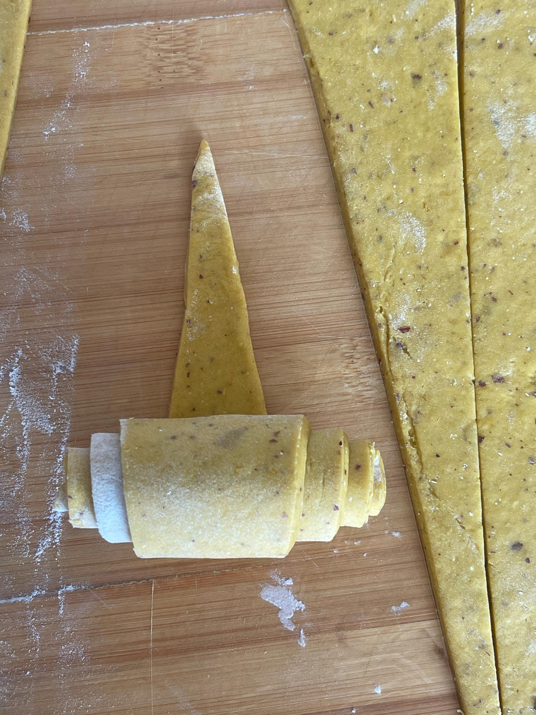 Rolling a dough triangle from the wide end into a horn shape