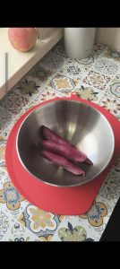 Purple sweet potatoes peeled on a cutting board