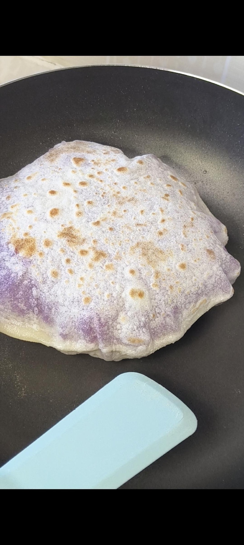 Purple sweet potato pancakes frying until golden