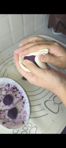 Purple sweet potato being wrapped in the dough