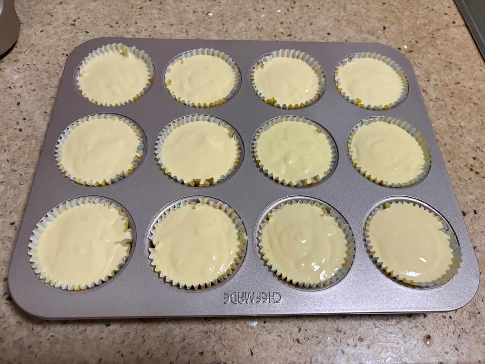 Paper cups filled with durian cheesecake batter