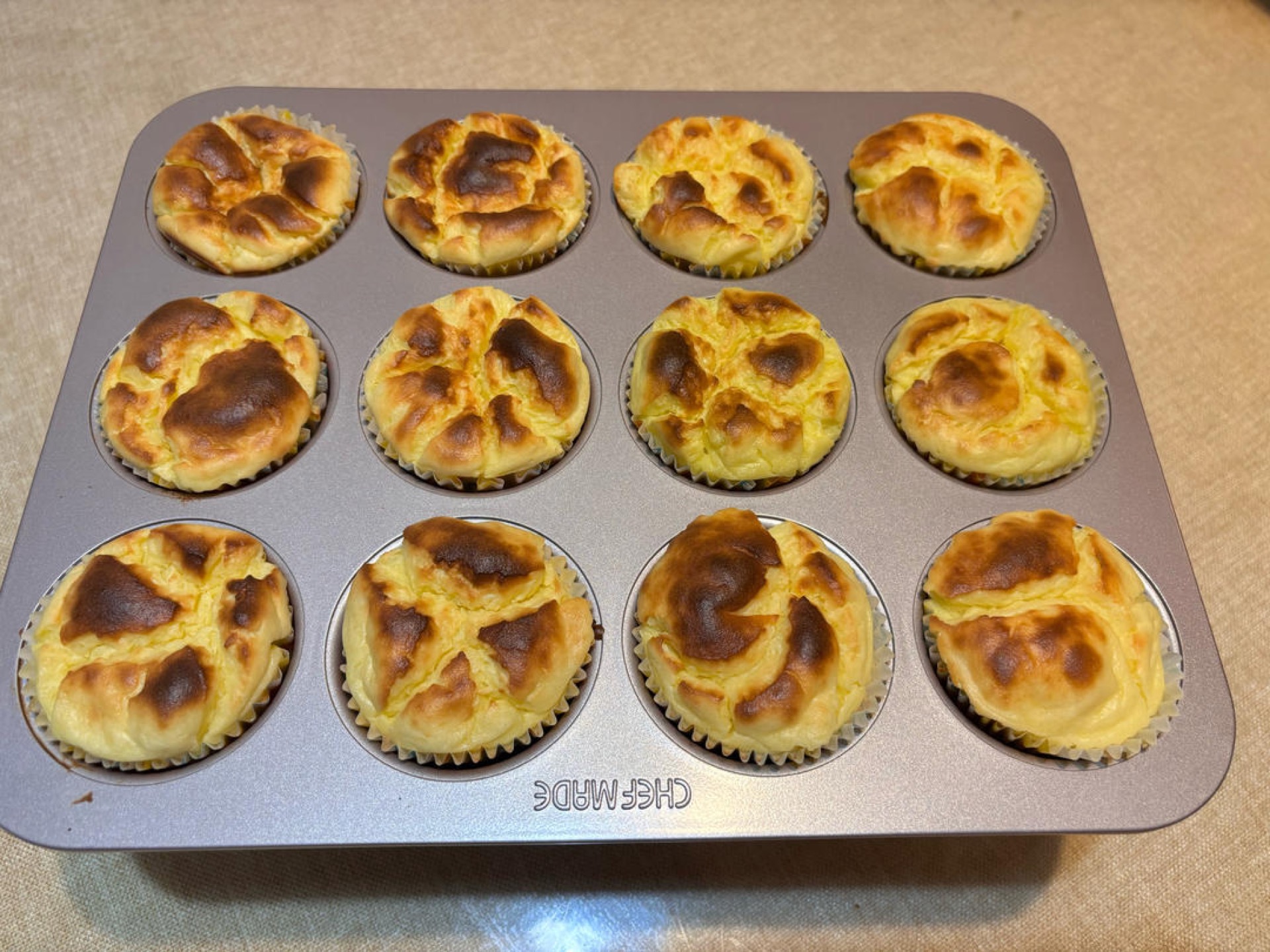 Freshly baked puffed durian cheesecake cups on a rack