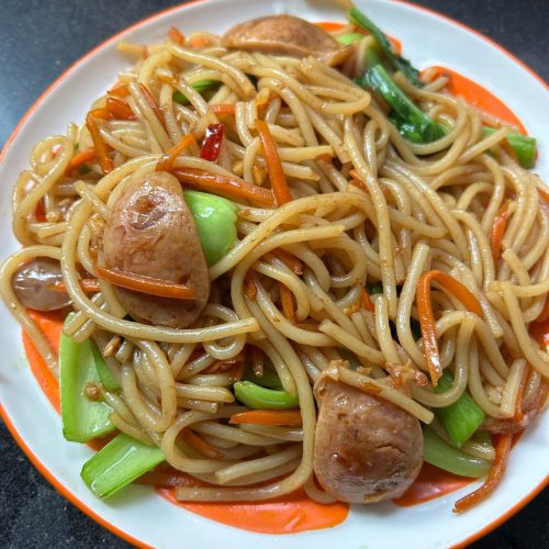 Quick stir-fried fresh rice noodles with carrot, bok choy, and Chinese sausage on a plate