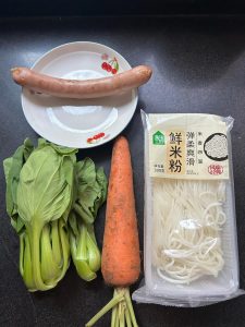 All ingredients for quick stir-fried fresh rice noodles laid out on a counter