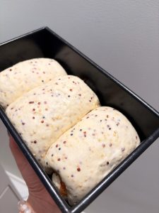 Shaped dough logs proofing in the loaf pan