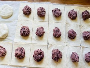 Spoonfuls of red bean paste placed on puff pastry squares