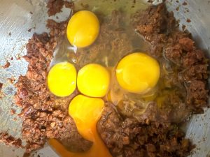Adding eggs to the cooled date paste