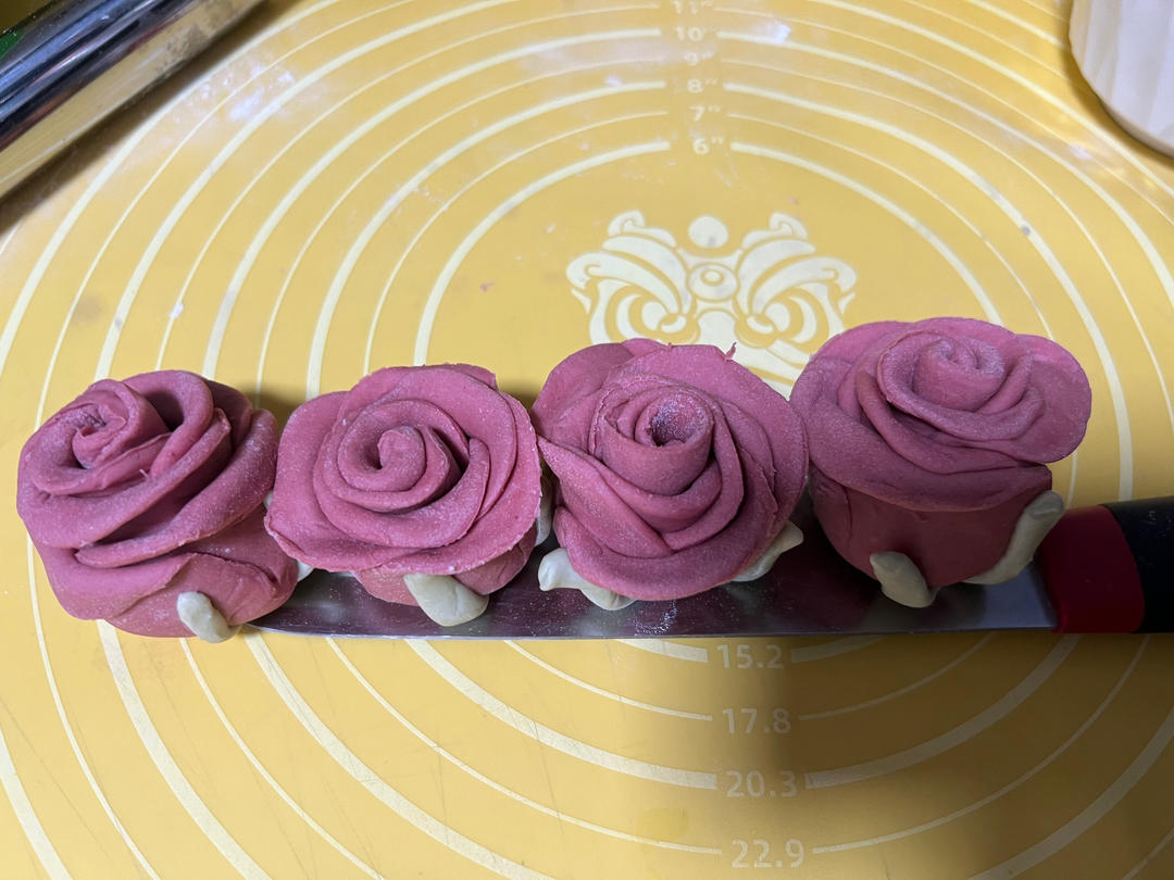 Green leaves attached to the base of the rose bun