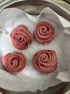 Rose buns proofing in the steamer until puffy