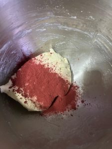 Red and green tinted dough portions on the work surface