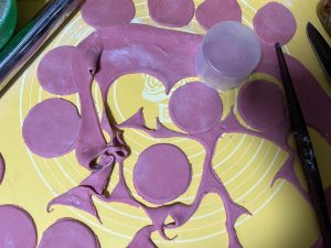 Round dough discs being cut from the red sheet