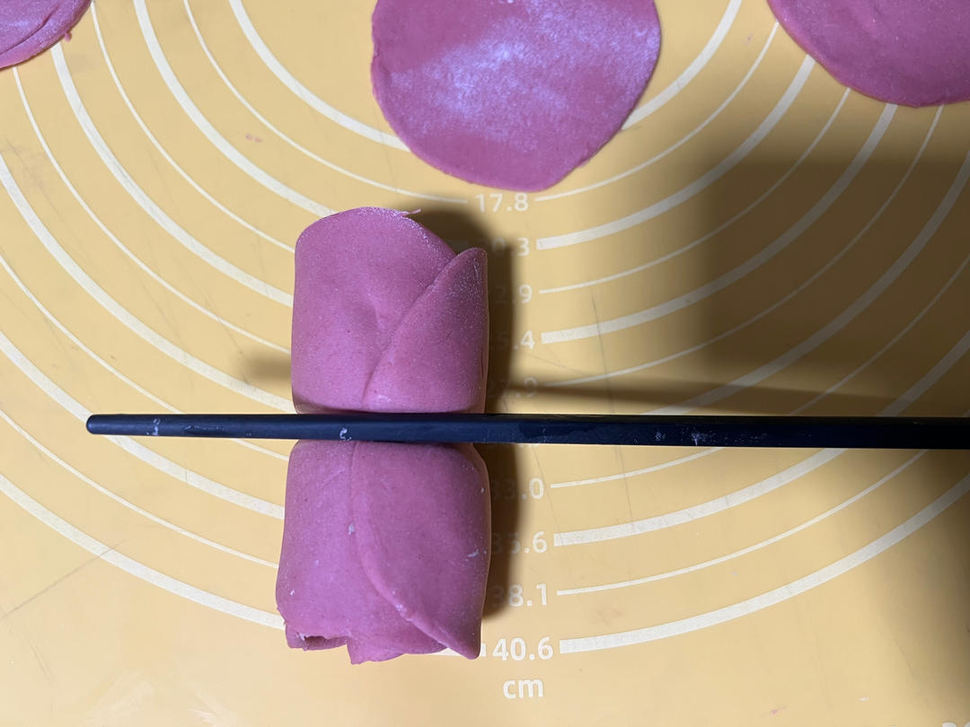 A dent being pressed into the middle of the dough log