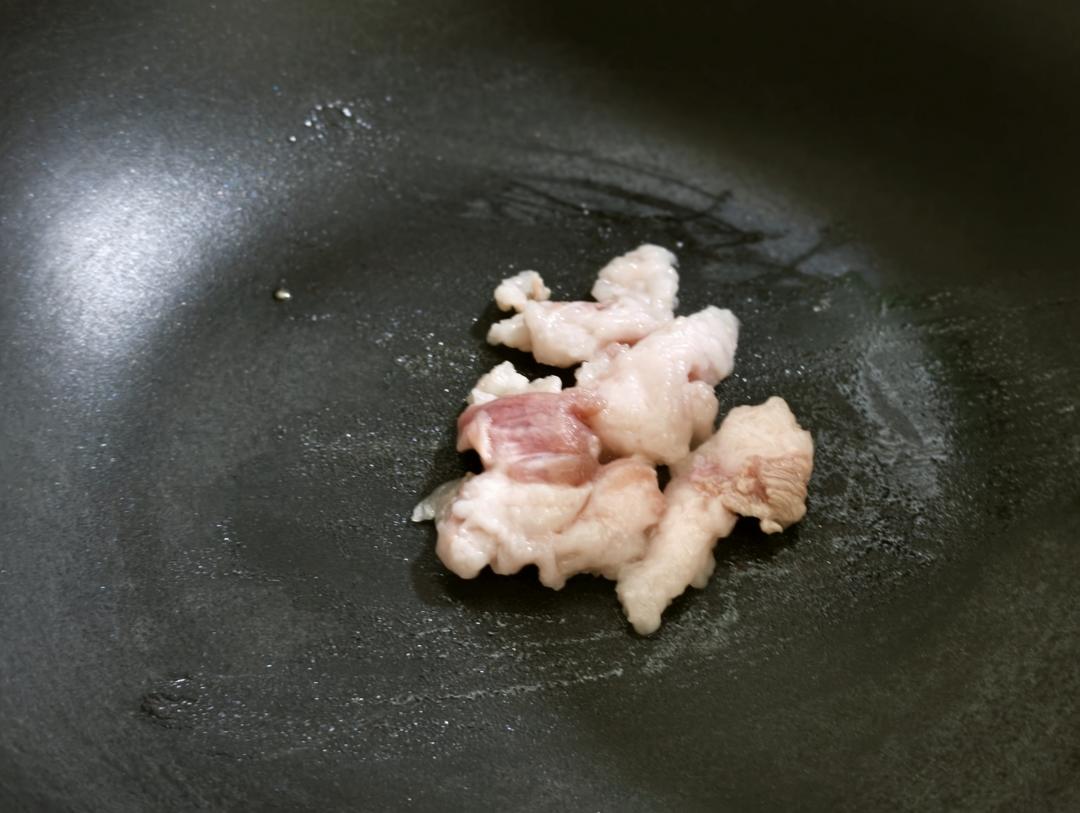 Pork belly rendering slowly in a dry pan