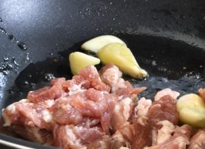 Garlic and pork frying in the rendered fat