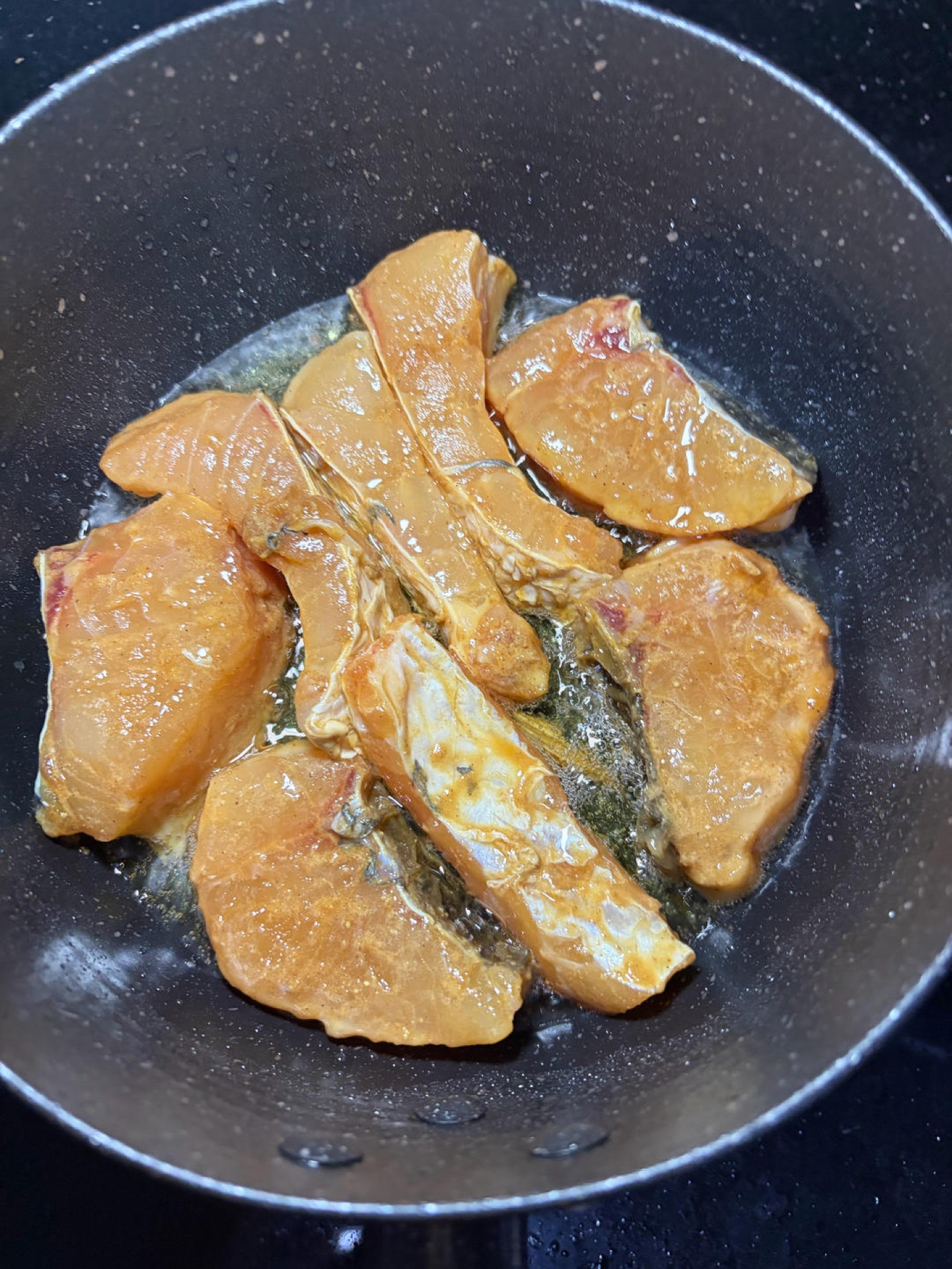 Leave a little oil in the wok, add the marinated fish pieces without moving them, and sear until one side is set and golden before flipping.