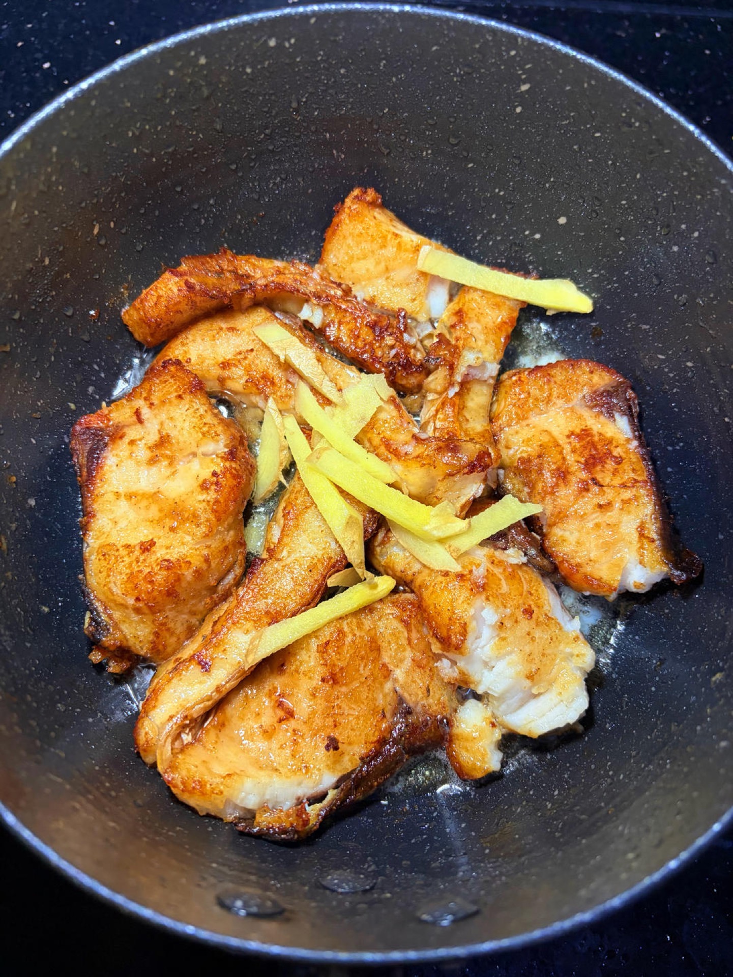 Add the julienned ginger, splash a little Shaoxing wine around the edge of the wok to boost aroma and cut the fishiness, and toss briefly.