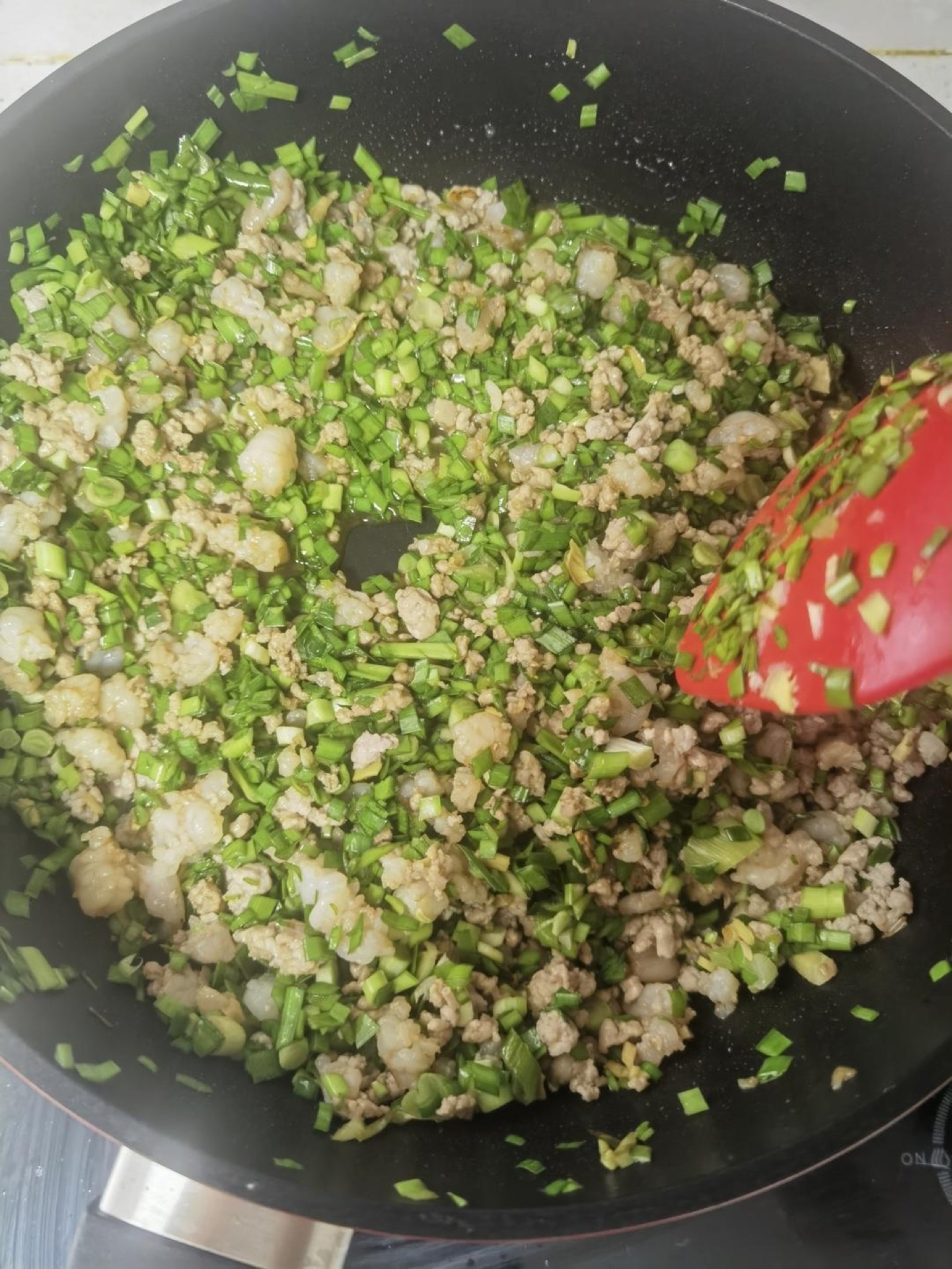 Sea worm and chive mixture glossy with sauce in a wok