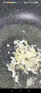 Heat oil in a separate wok, add the scallions and minced garlic, and stir-fry until fragrant.