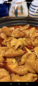 Pour the cooked intestines and their braising liquid over the vegetables in the clay pot.