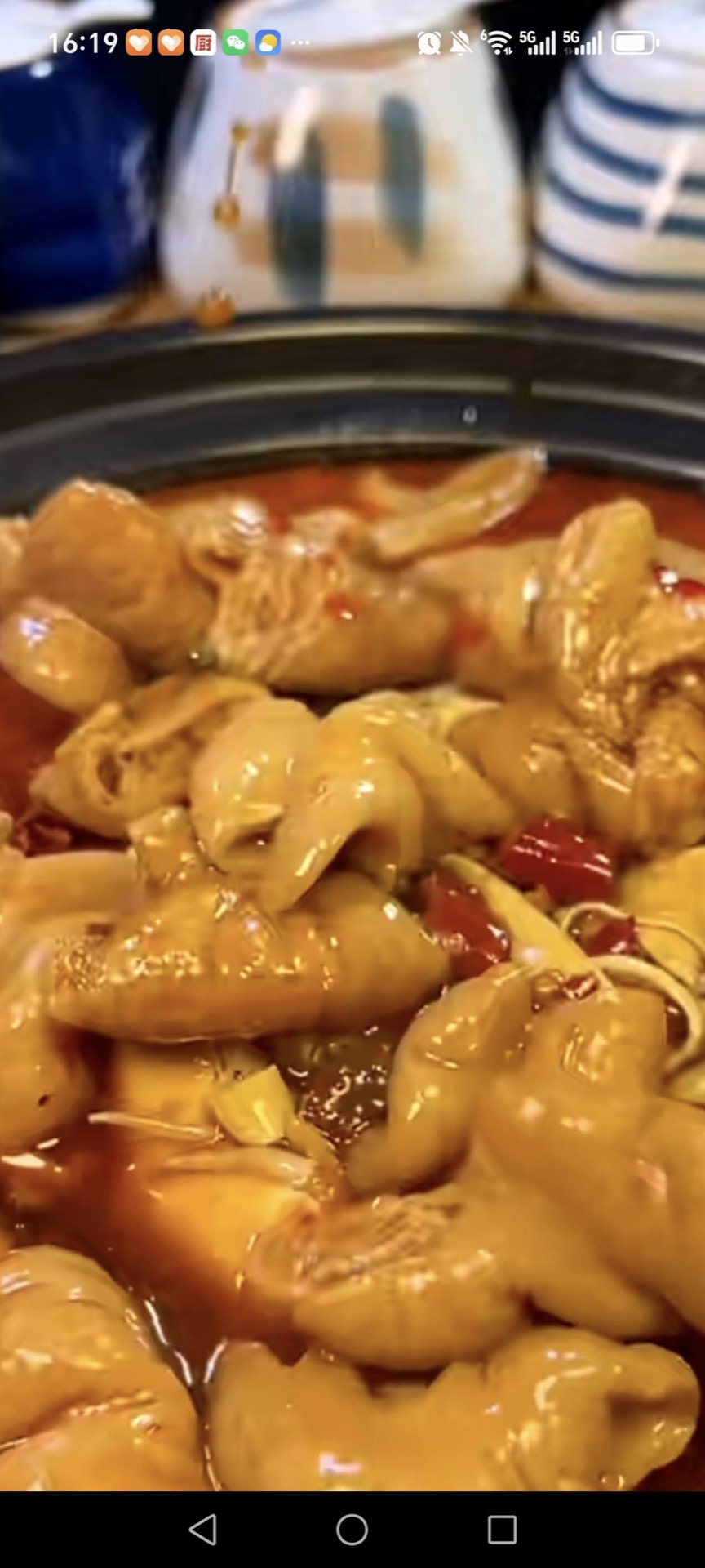 Pour the cooked intestines and their braising liquid over the vegetables in the clay pot.