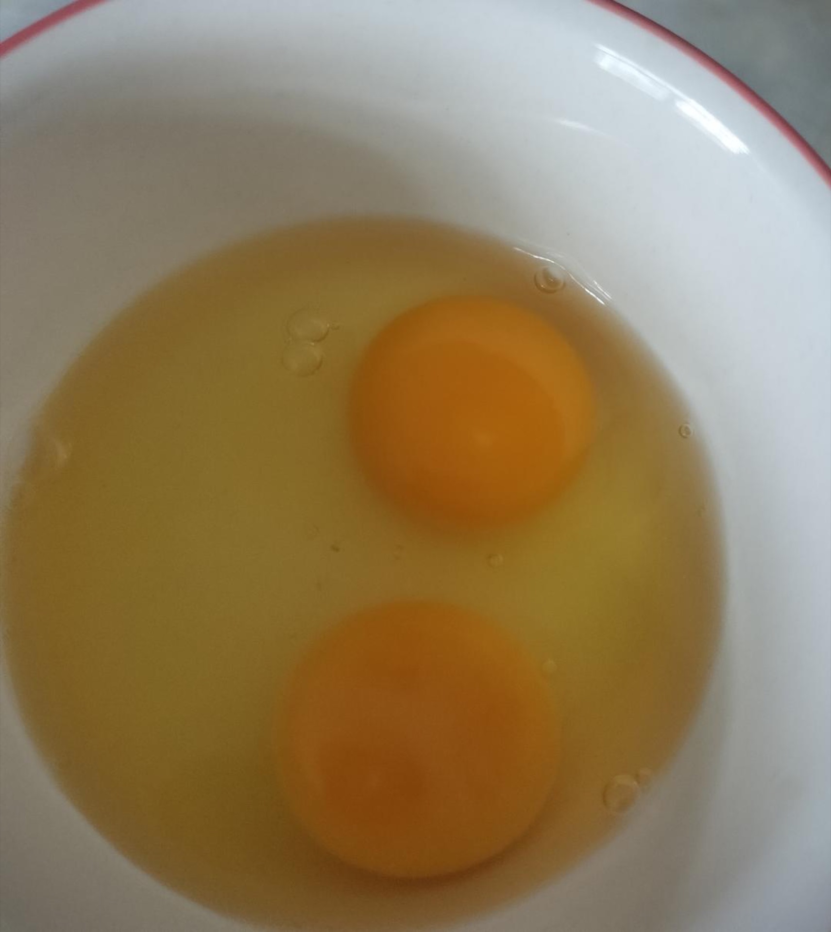 Crack two eggs into a bowl.