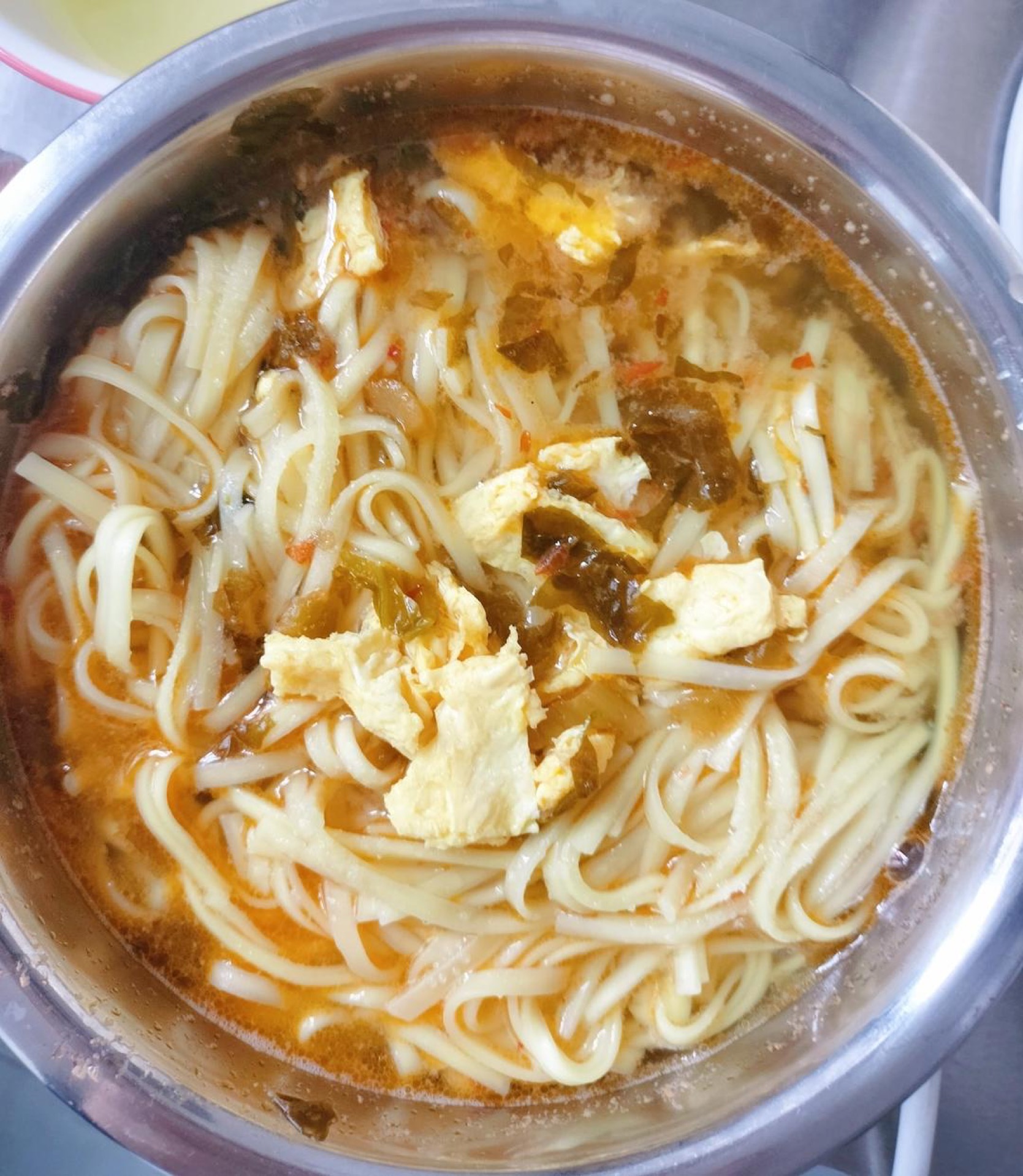 Pour the soup into a serving bowl, wash the wok, boil fresh water, and cook the noodles until just tender; drain them into the bowl, season with salt and chili oil, and serve.