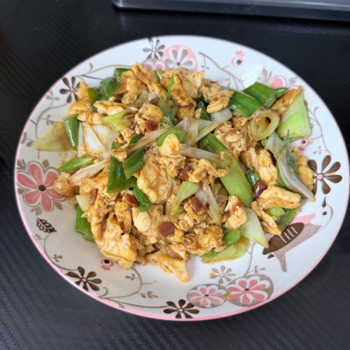 Soy sauce scrambled eggs with scallions served in a white dish