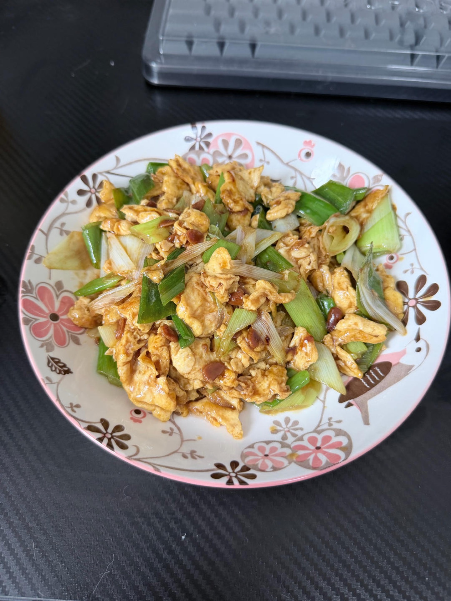 Soy sauce scrambled eggs with scallions served in a white dish