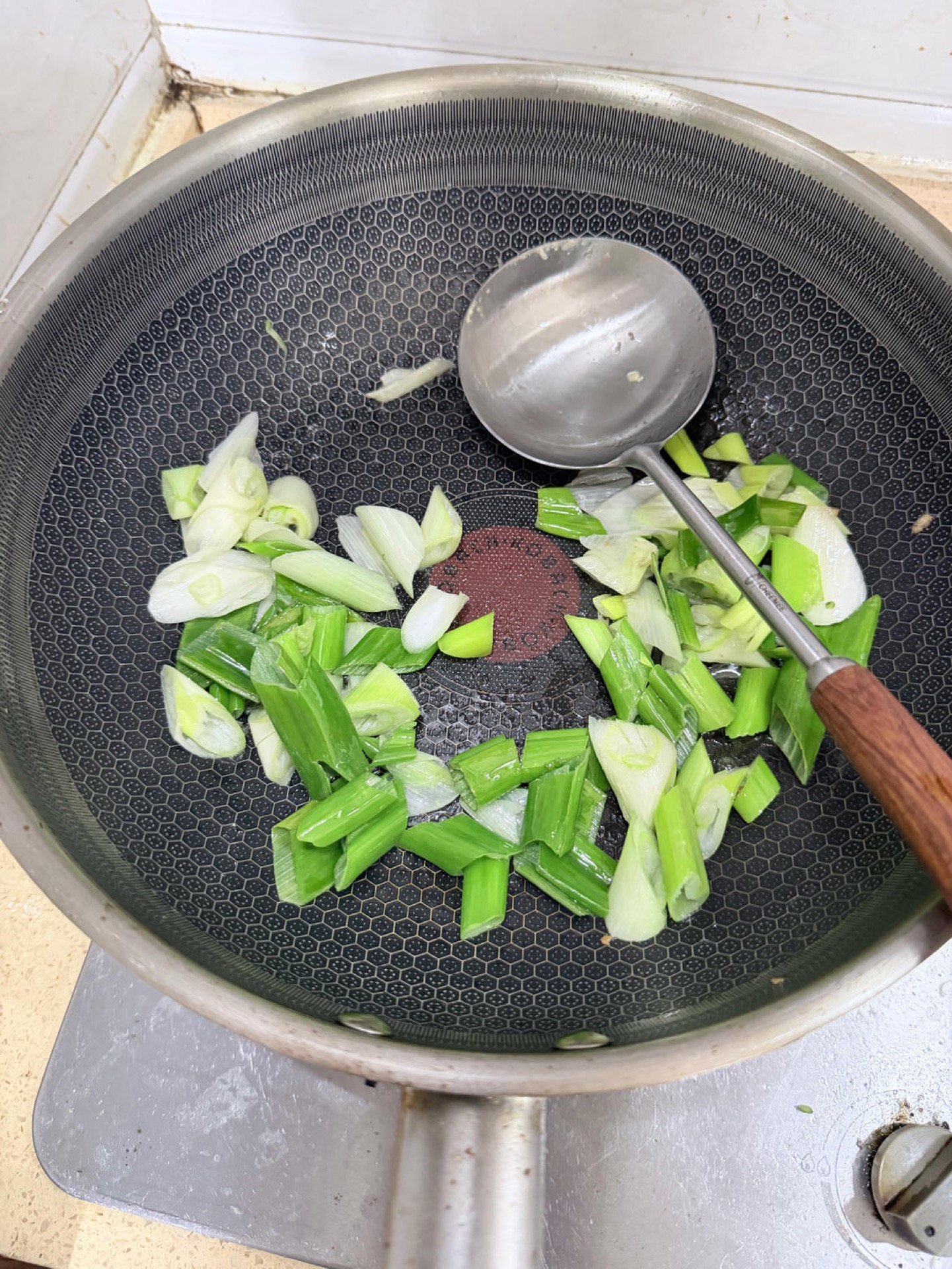 Add the remaining oil and the scallion sections to the hot wok and stir-fry just until they soften slightly and smell sweet, not until they brown.