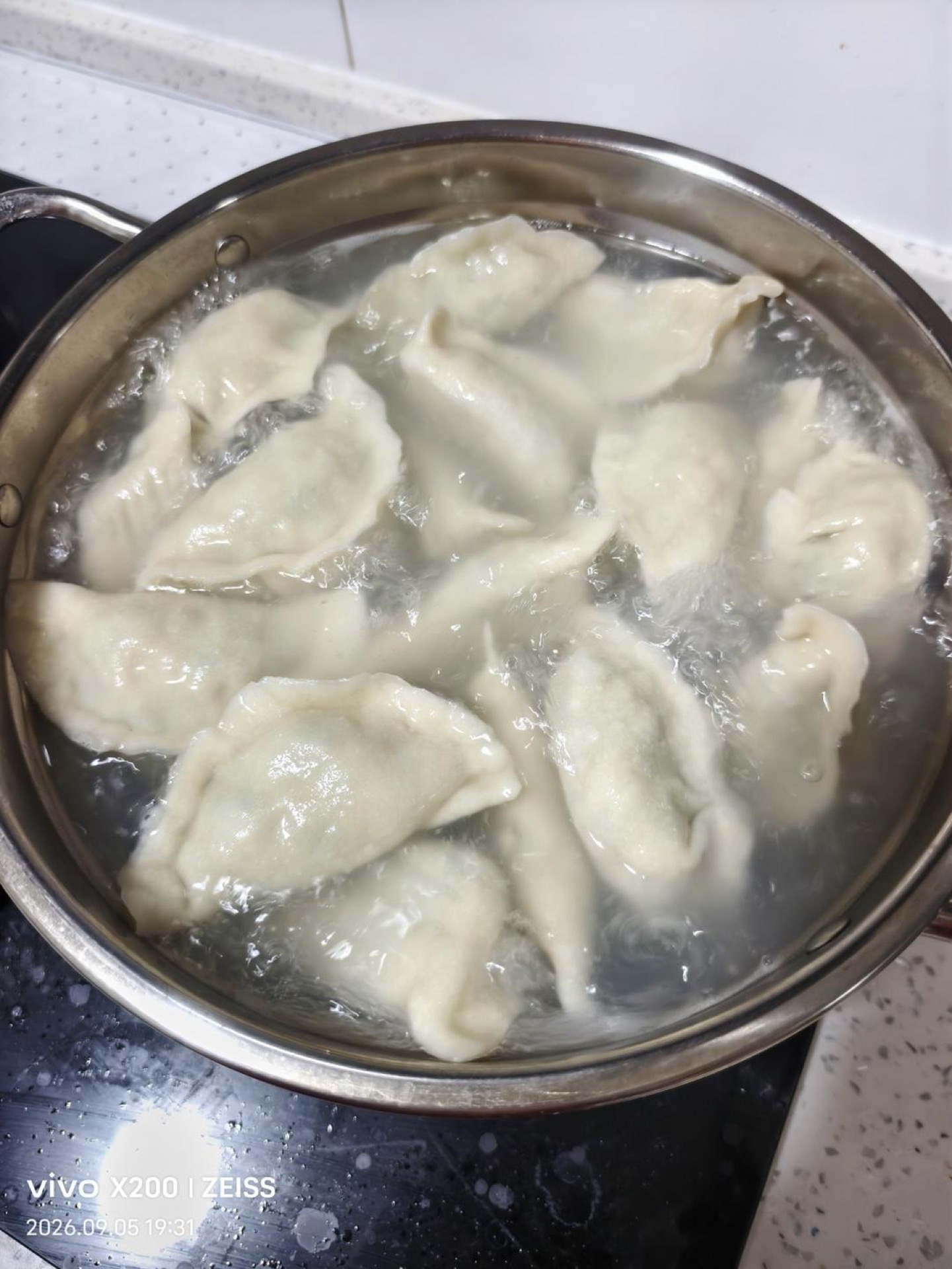 Spanish mackerel dumplings (鲅鱼水饺) piled on a plate with black vinegar dipping sauce