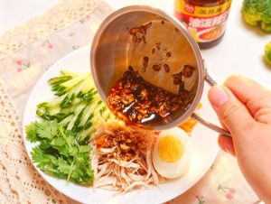 Pile the shredded chicken over the cucumber and carrot, pour the dressing over the top, and toss thoroughly until every strand is coated, then add the halved egg and serve.