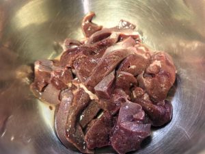 Pork liver sliced thin on a cutting board