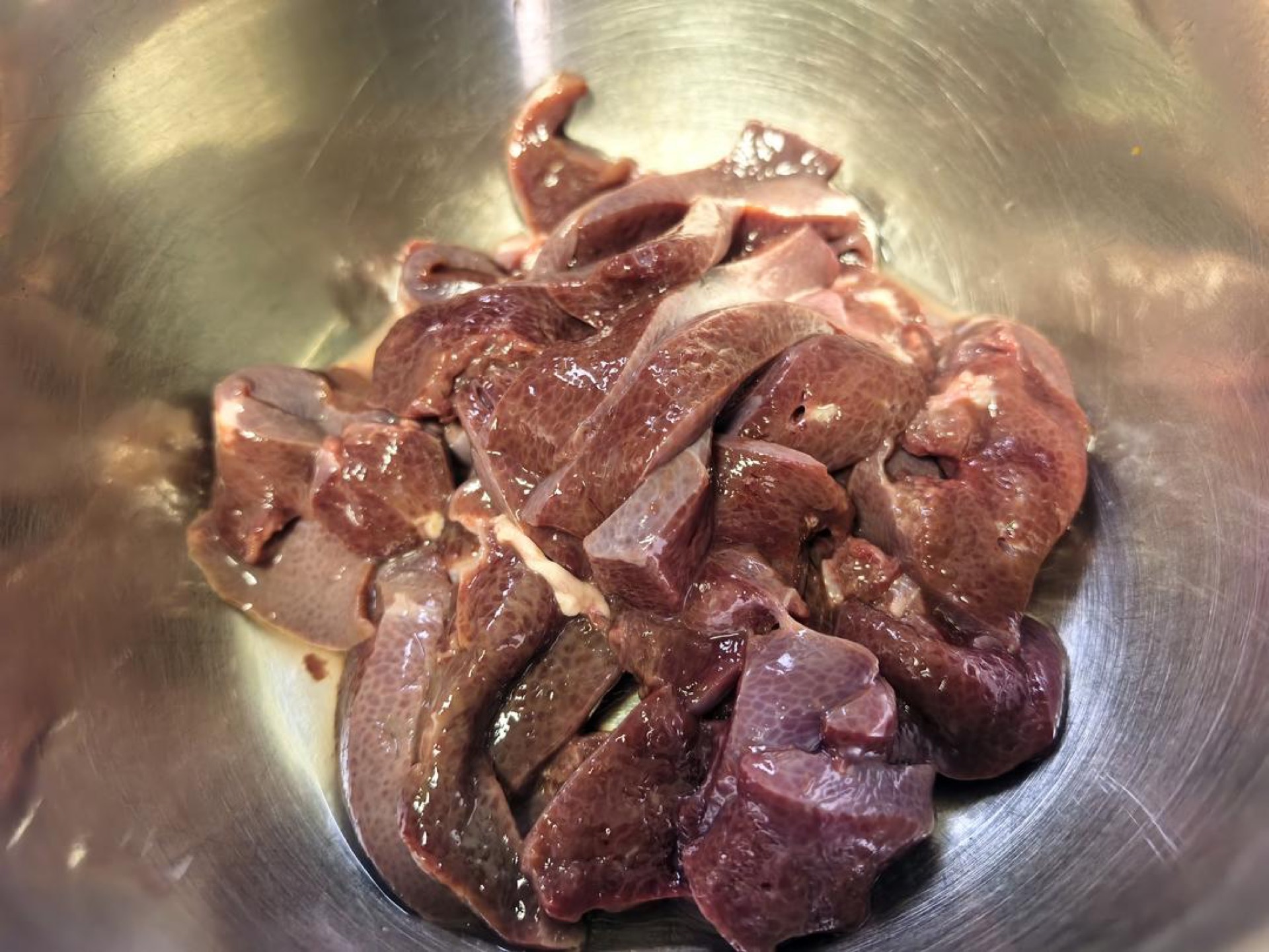 Pork liver sliced thin on a cutting board