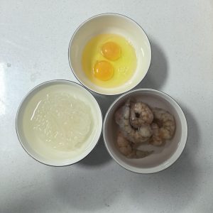 Soak the frozen shrimp to thaw, soak a bundle of vermicelli in warm water until pliable, and beat two eggs in a small bowl.