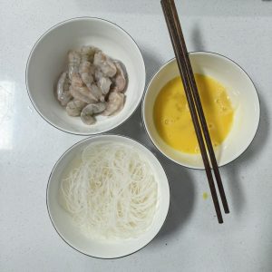 Snip the soaked vermicelli into shorter lengths, butterfly the shrimp and pull the dark vein, and cut very large shrimp into segments.