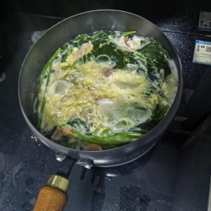 When the water comes to a boil, add the spinach, vermicelli, shrimp, and beaten egg in that order.