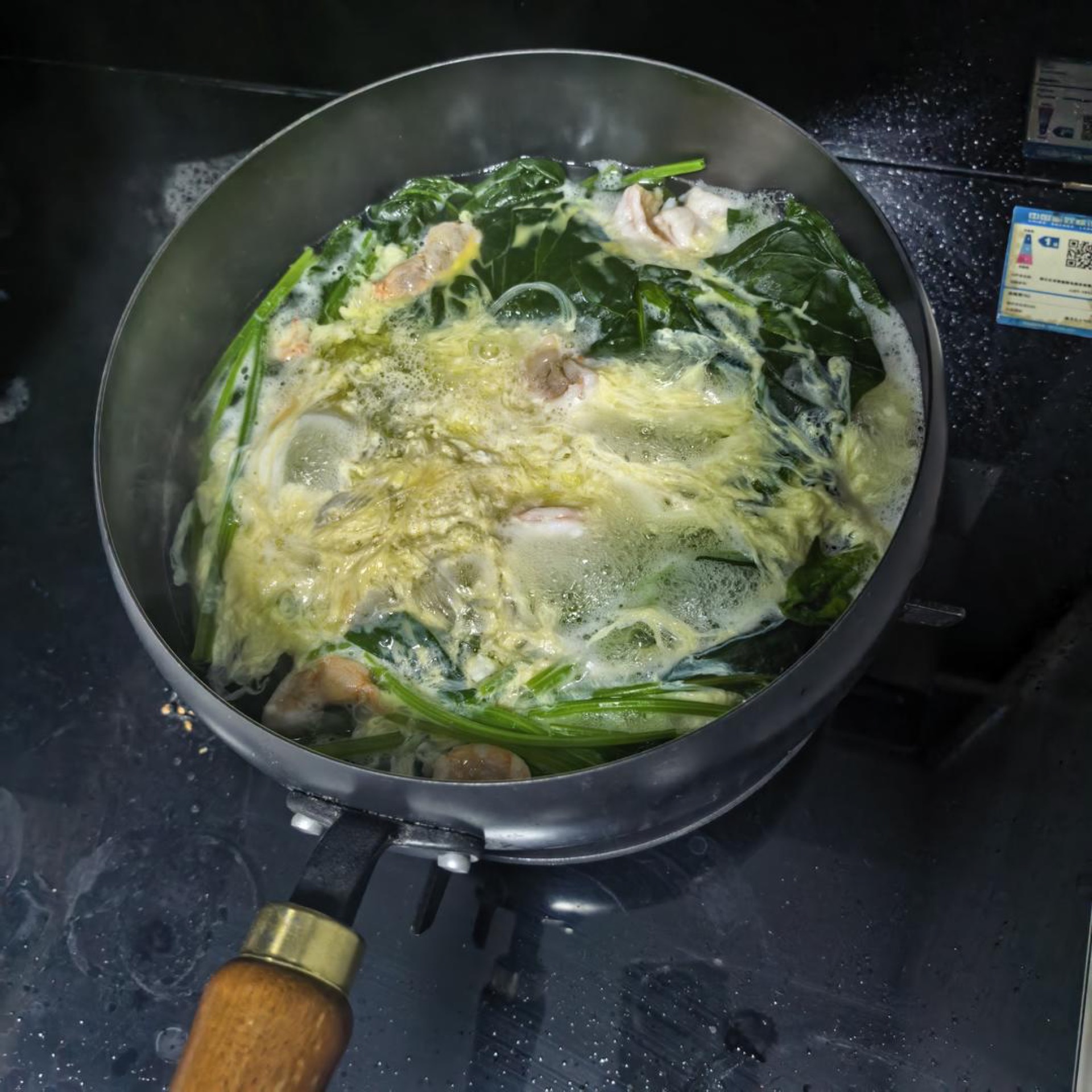 When the water comes to a boil, add the spinach, vermicelli, shrimp, and beaten egg in that order.