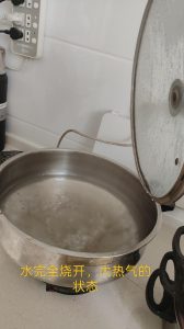 Pot of water at a rolling boil with steam rising