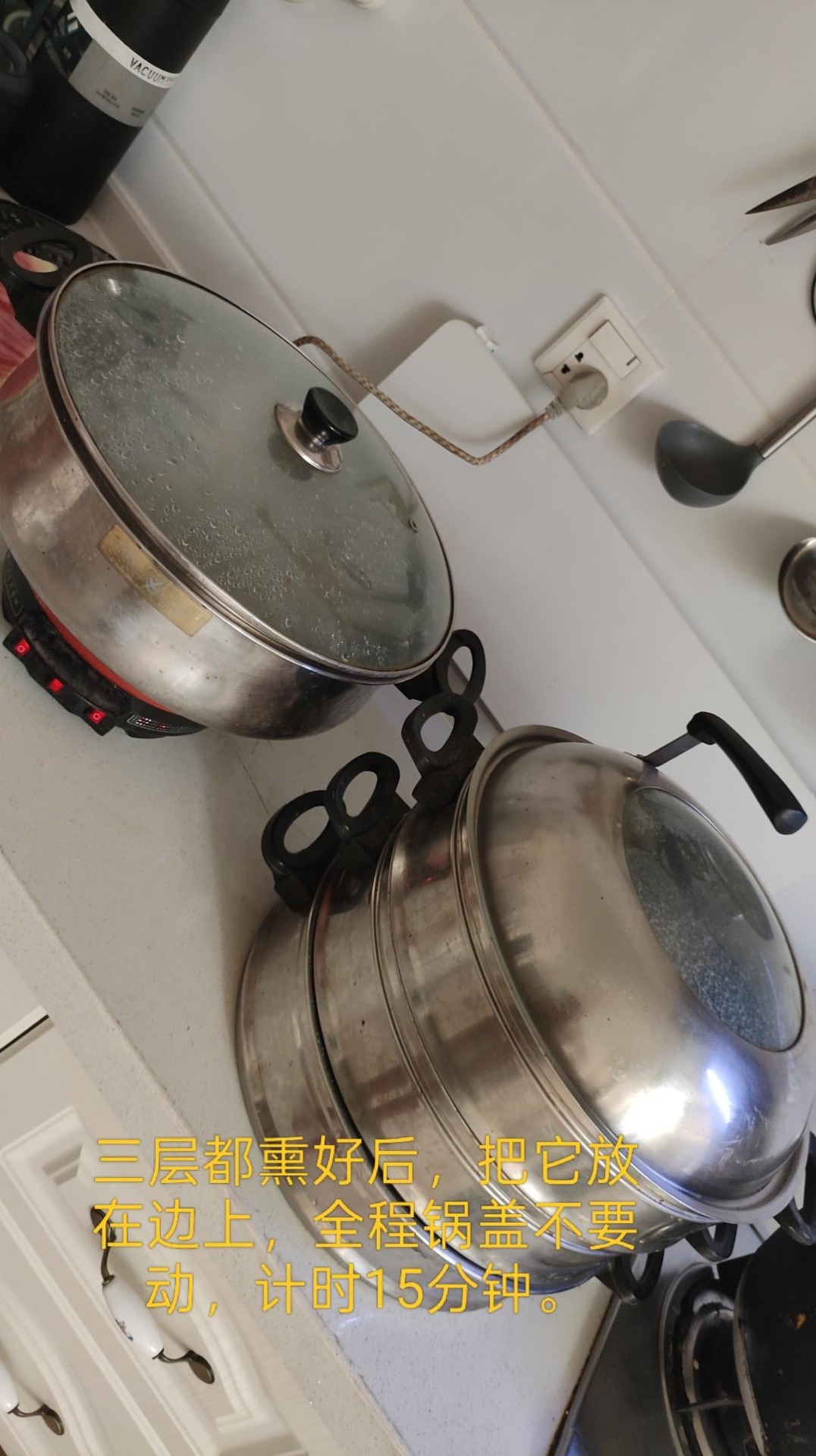 Three stacked steamer tiers with lid resting on the table