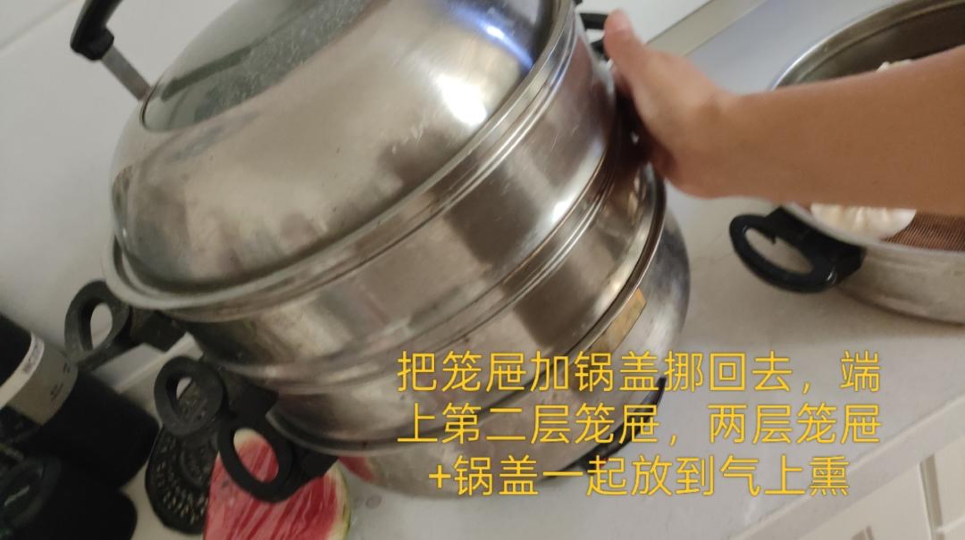 Two steamer tiers stacked and held over the pot