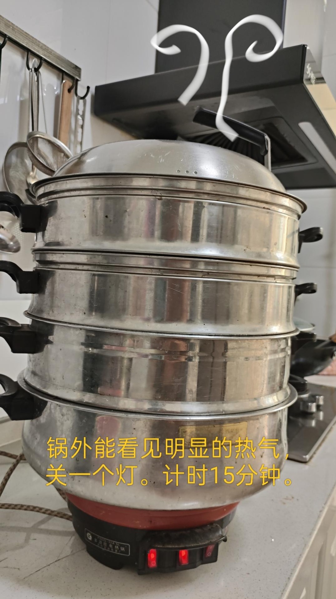 Steamer tiers on the pot with steam rising around the edges