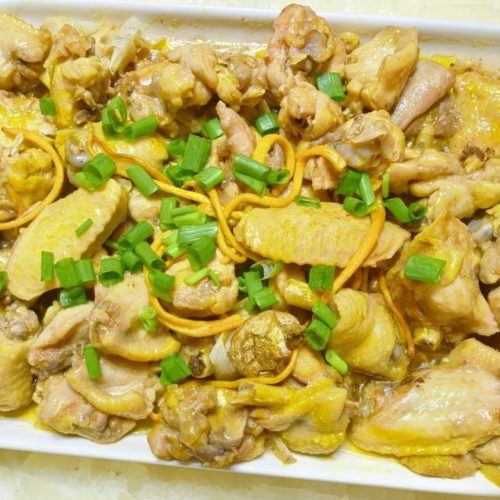 Steamed chicken with cordyceps flowers (虫草花蒸鸡) in a white steaming dish, garnished with chopped scallion