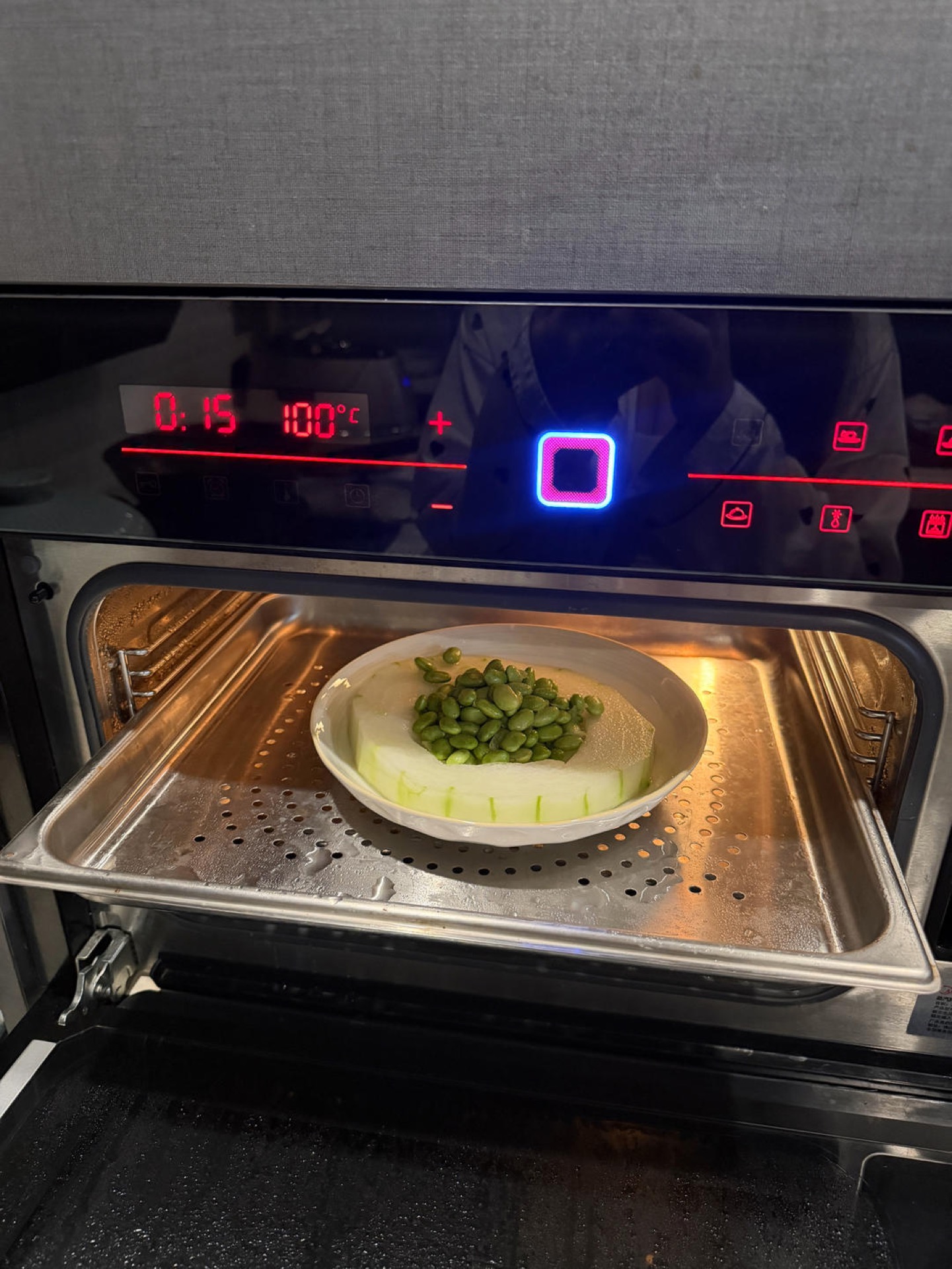 Peel the winter melon, scoop out the seeds, and hollow the center a little wider than you think you need. Shell and rinse the fresh edamame. Sprinkle the melon with a little salt a