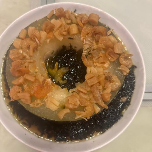 Steamed winter melon rings topped with dried scallop and dried shrimp in a white dish