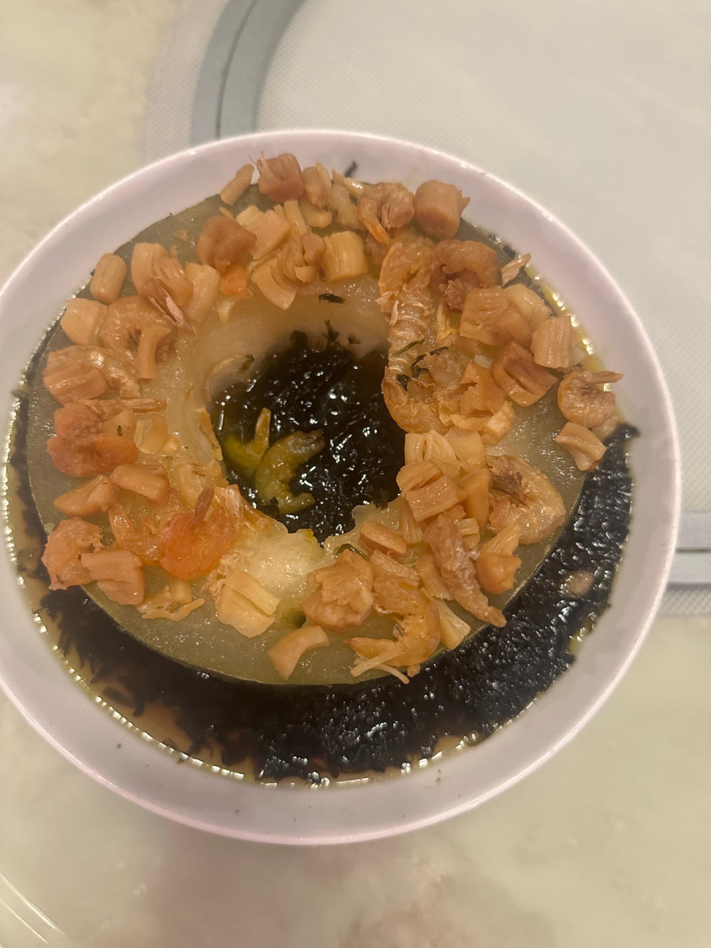 Steamed winter melon rings topped with dried scallop and dried shrimp in a white dish
