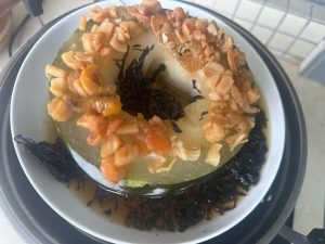 Crumble the dried seaweed by hand, scatter it around the melon and into the juices in the center, and keep steaming until the winter melon is fully tender and soft.