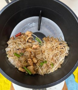 Set the wok to stir-fry mode: add oil, garlic, scallion, Thai chili, and green beans, and cook for 2 minutes; add the rice noodles and stir-fry for 2 minutes; add the cooked chicke