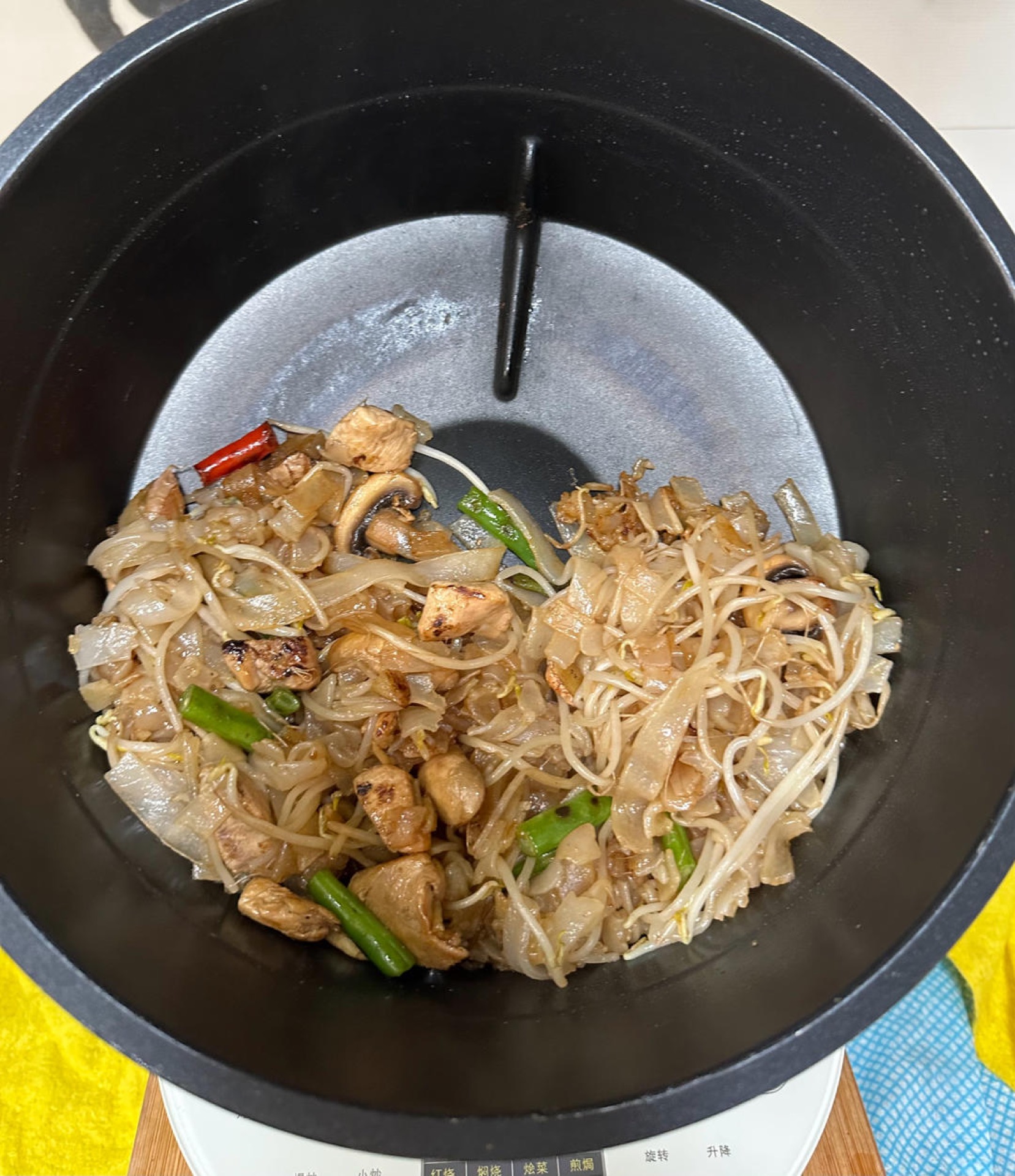 Set the wok to stir-fry mode: add oil, garlic, scallion, Thai chili, and green beans, and cook for 2 minutes; add the rice noodles and stir-fry for 2 minutes; add the cooked chicke