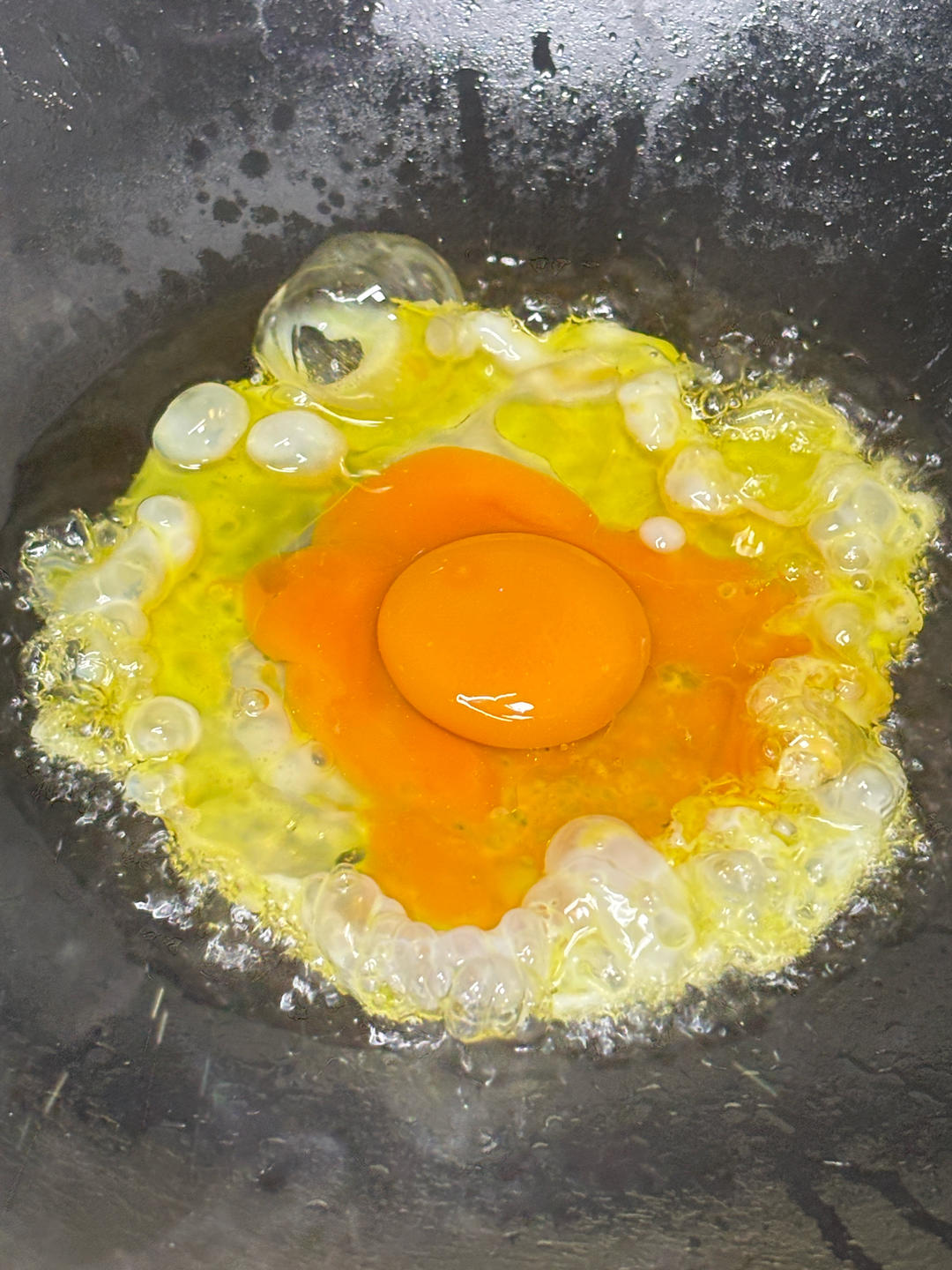 Frying the egg in the hot wok