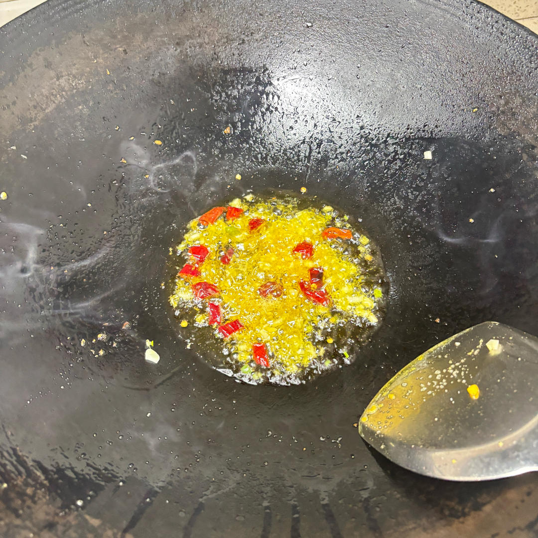 Frying garlic and dried chilies in the wok